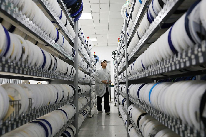 工作人员在国网电科院（南瑞集团）的生产车间里加工产品（6月30日摄）。新华社记者鲁鹏摄